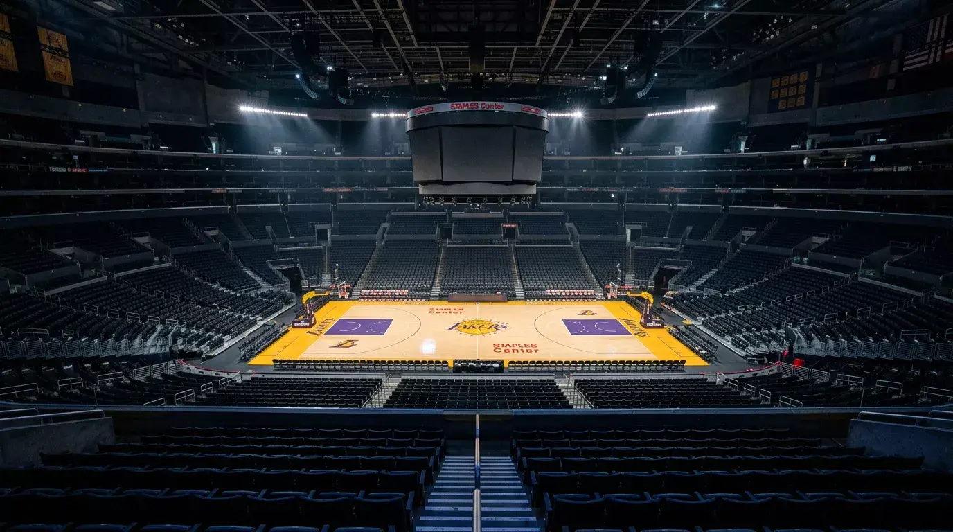 Pista de baloncesto NBA vacia vista desde las gradas superiores con focos encendidos iluminando la cancha